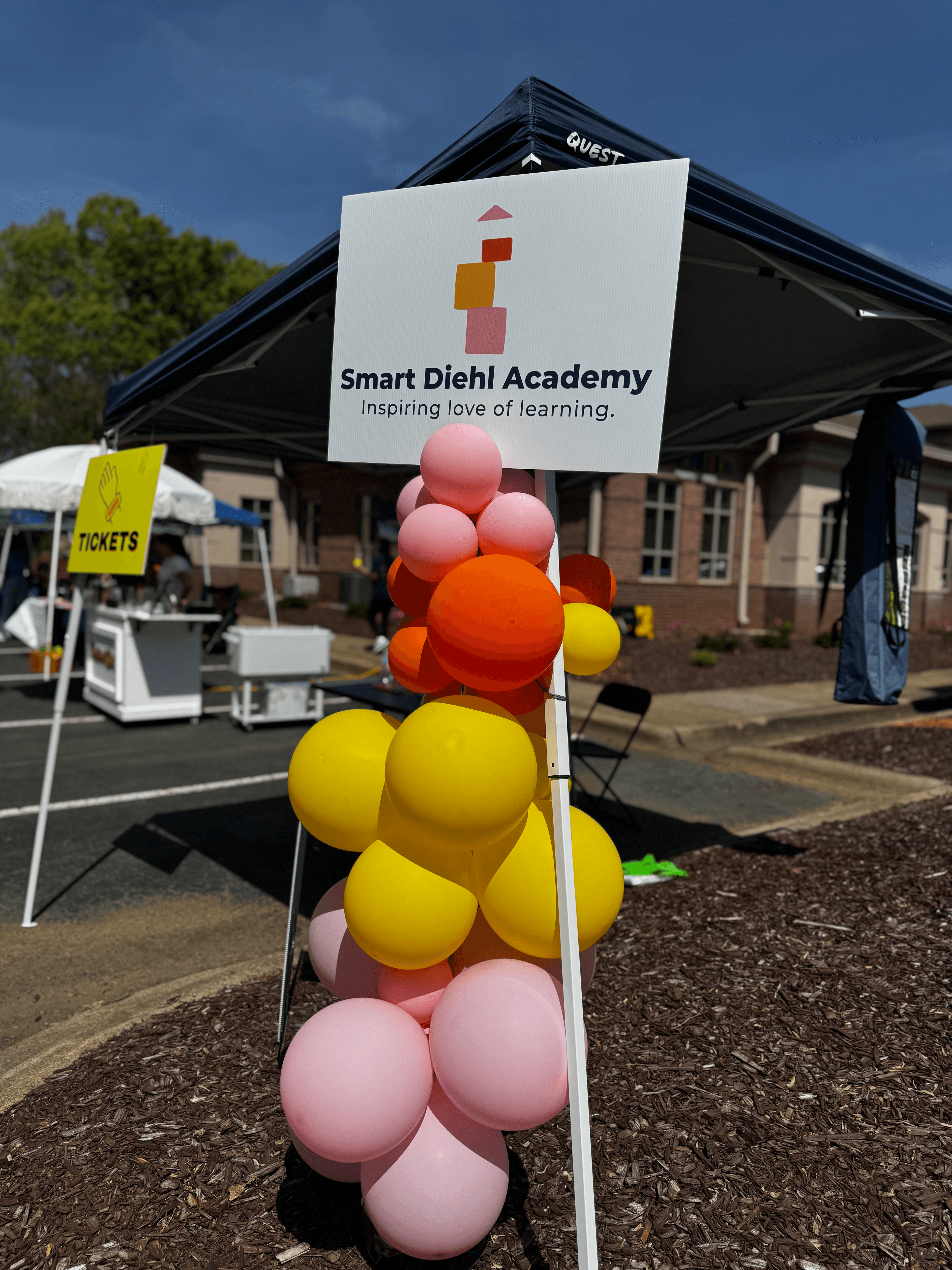 Smart Diehl Academy branded event sign surrounded by a colorful balloon cluster